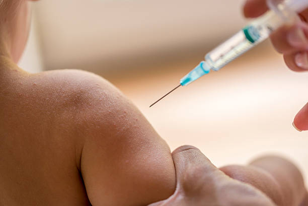 Doctor injecting a young child stock photo