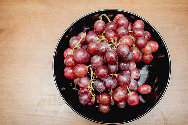 raisins dans une plaque noire - lambrusco photos et images de collection