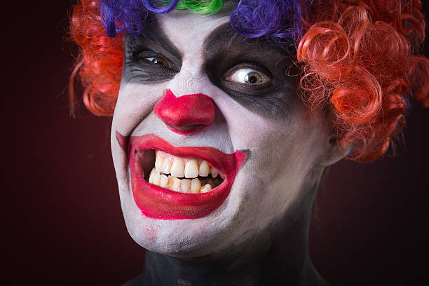 istock Evil Spooky Clown Portrait on dark background. expressive man 496386228