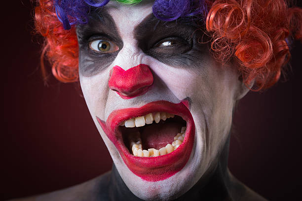 istock Evil Spooky Clown Portrait on dark background. expressive man 496386250