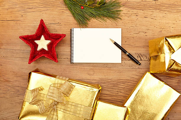 istock Christmas presents, notepad and fir twig on wood 496387010
