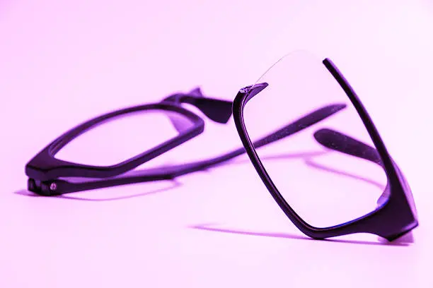 Closeup of Broken plastic Eyeglasses on colored background