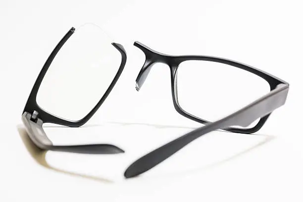 Closeup of Broken plastic Eyeglasses on colored background