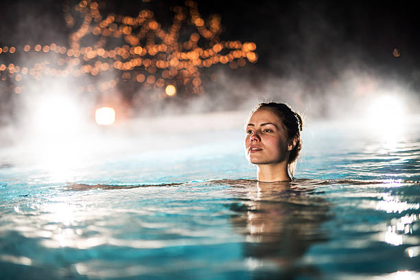 Woman spending a winter night in a heated swimming pool.