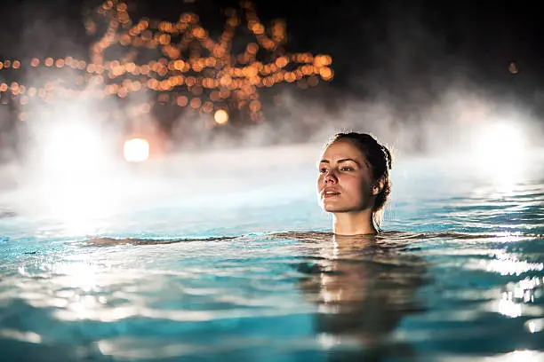 Photo of Woman spending a winter night in a heated swimming pool.