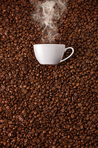 istock White cup with hot steam smoke at coffee beans 496388946