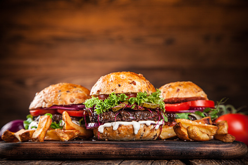 Delicious hamburgers on wooden background