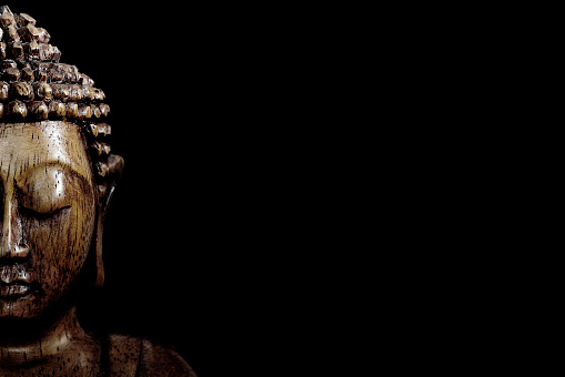 Wooden buddha statue on table shot in studio