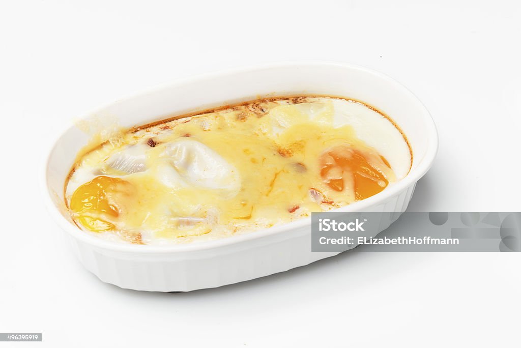 Baked egg Two free range Baked egg, bacon; tomato, chilly and cheese for breakfast in an oval white oven proof dish Bacon Stock Photo