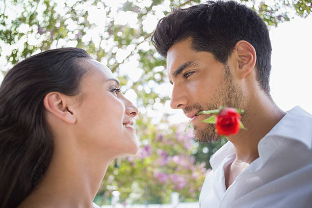 istock Boyfriend with red rose looks at girlfriend romantically 496398871