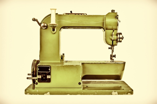 Retro styled image of an old sewing machine against a light sepia background
