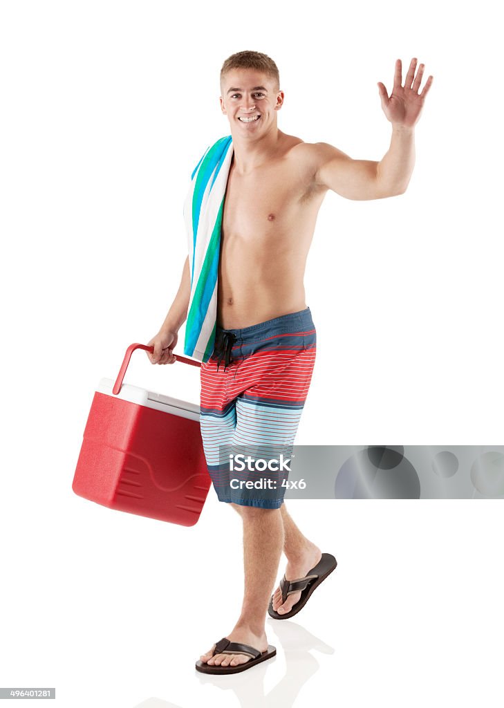 Feliz jovem caminhando com refrigerador e acenando - Foto de stock de 20 Anos royalty-free