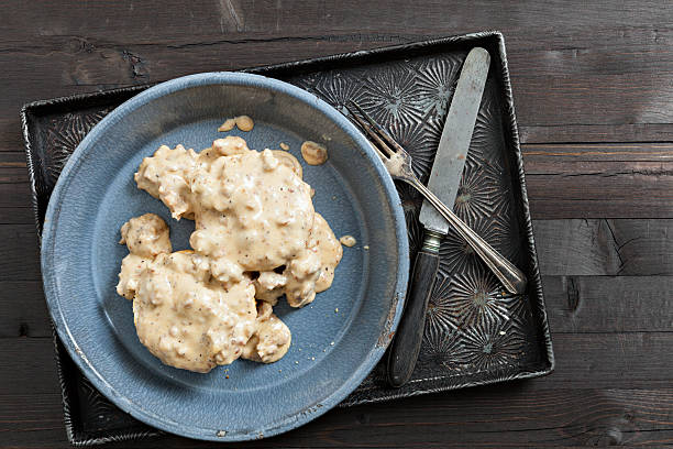 Grandmas Biscuits And Gravy An overhead close up shot of grandma's biscuits and gravy. gravy stock pictures, royalty-free photos & images