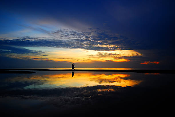 istock silhouette walk on the beach in morning 496402951