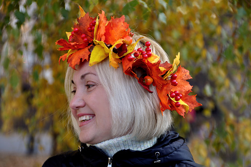 Happy girl with wreath of autumn leaves
