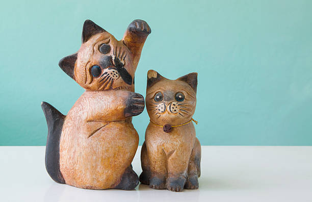 istock carved wooden cats on a table with green backgrounds 496404564