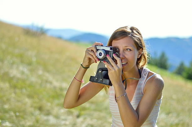 istock Young and  beautiful woman holding a retro camera 496407226