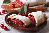 Pieces of strudel with cherry close-up on a plate. horizontal