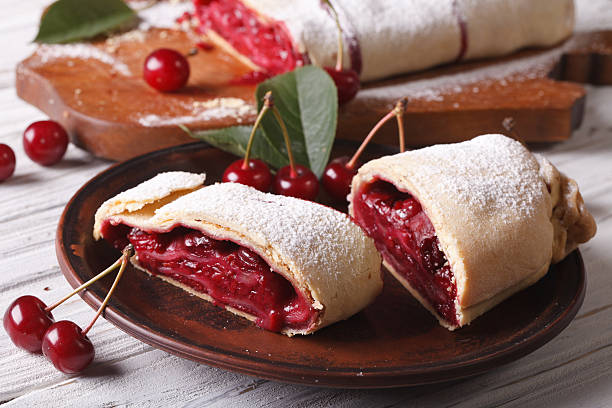 Pieces of strudel with cherry close-up on a plate. horizontal Slices of homemade strudel with cherry close-up on a plate. horizontal strudel stock pictures, royalty-free photos & images