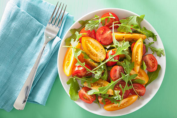istock tomato salad with arugula over green background 496412984