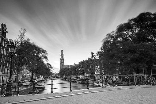 Beautiful long exposure of the Westerkerk church at the UNESCO world heritage Prinsengracht canal in Amsterdam in black and white