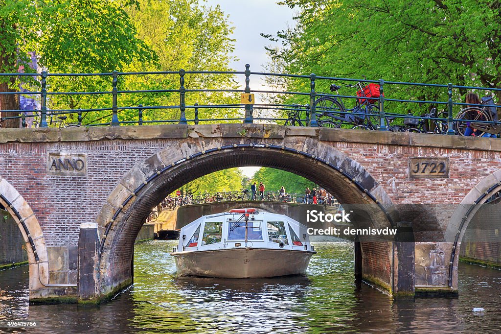 Bridge canal cruise Canal cruise boat goes under the bridge over the Leidse canal at the Patricians' or Lords' canal (Herengracht) in Amsterdam in spring Amsterdam Stock Photo