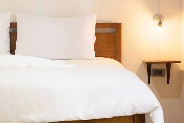 white duvet on vintage wood bed.