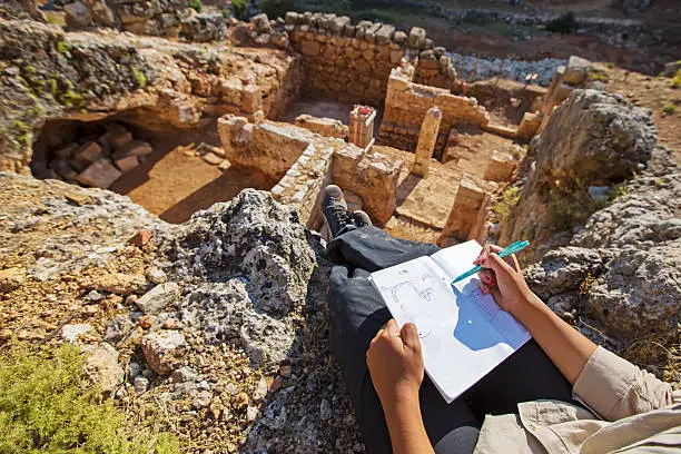 Archeaologist working and notes on site