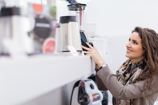 Beautiful woman choosing new blender in homeware store