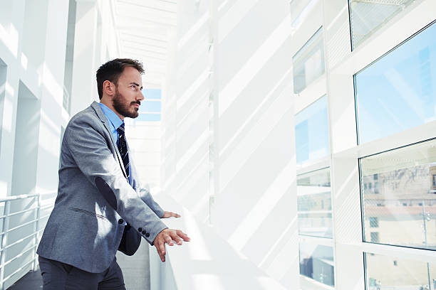 istock Men entrepreneur dressed in luxury clothes looking in office window 496435542