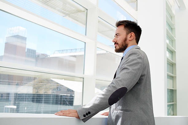 istock Businessman conceived looks in office window while rest after conference, 496435774