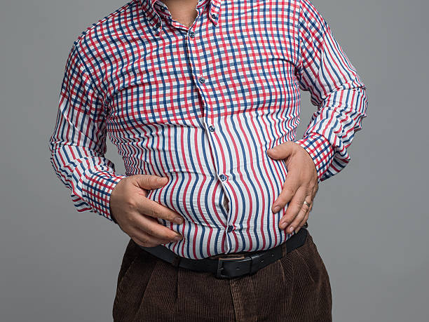 istock Overweight man holding pot belly, close up 496436456