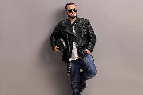 istock Young male biker leaning against a wall 496437834