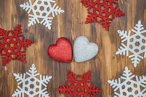 white and red shiny snowflakes and heart shape decoration on wood, lover