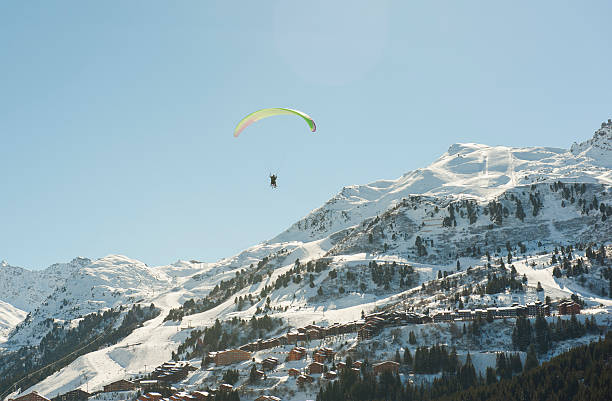 Paraglider flying over a mountain valley stock photo