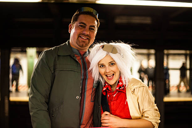 New York City, NY, USA - October 31, 2015: Couple dressed as Back to the Futures characters, Doc and Marty for Halloween. In train station. 