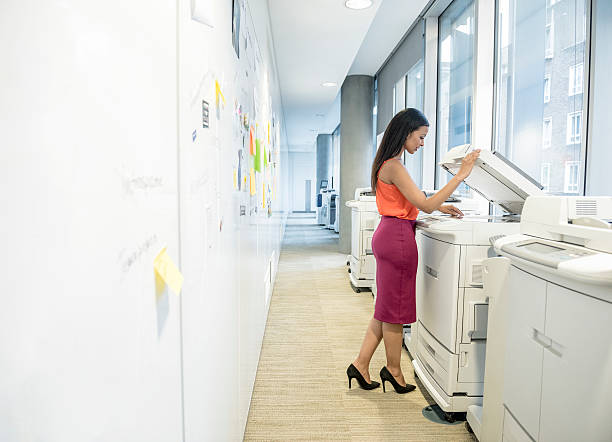 istock Young female office worker using photocopier 496442606
