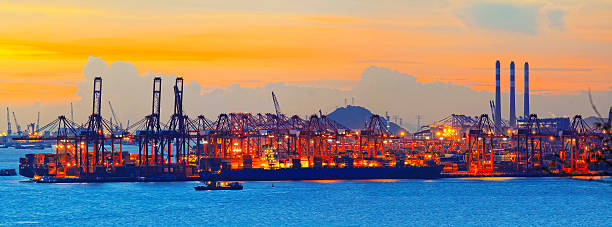 Silhouette of several cranes in a harbor, shot during sunset. stock photo