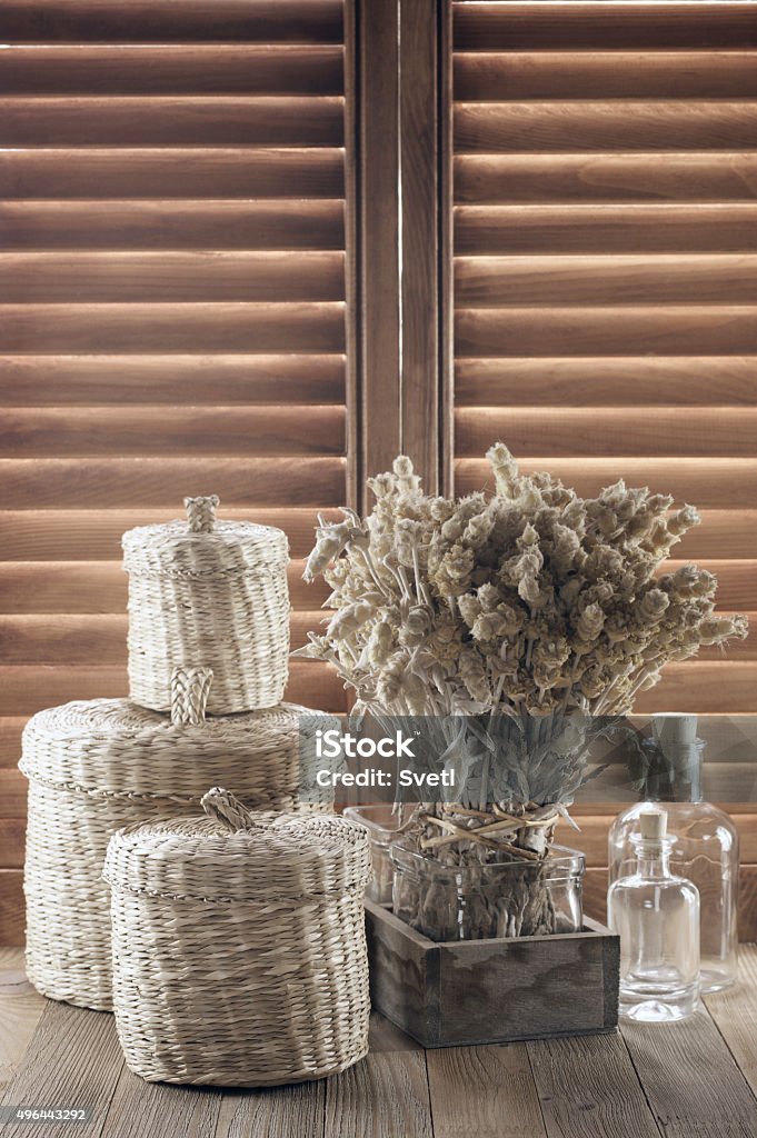 Rustic kitchen utensil Rustic kitchen utensil against wooden shutters: bunch of dry flowers, glass bottles and wicker baskets. 2015 Stock Photo