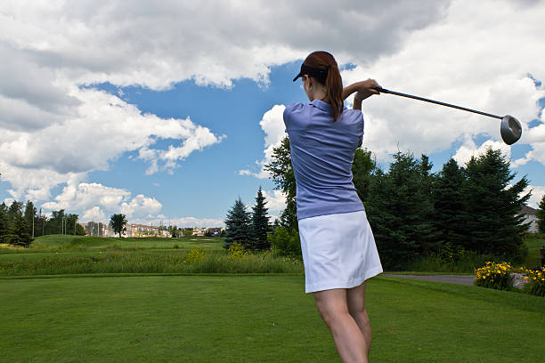 istock Female golfer swinging her golf club 496443955