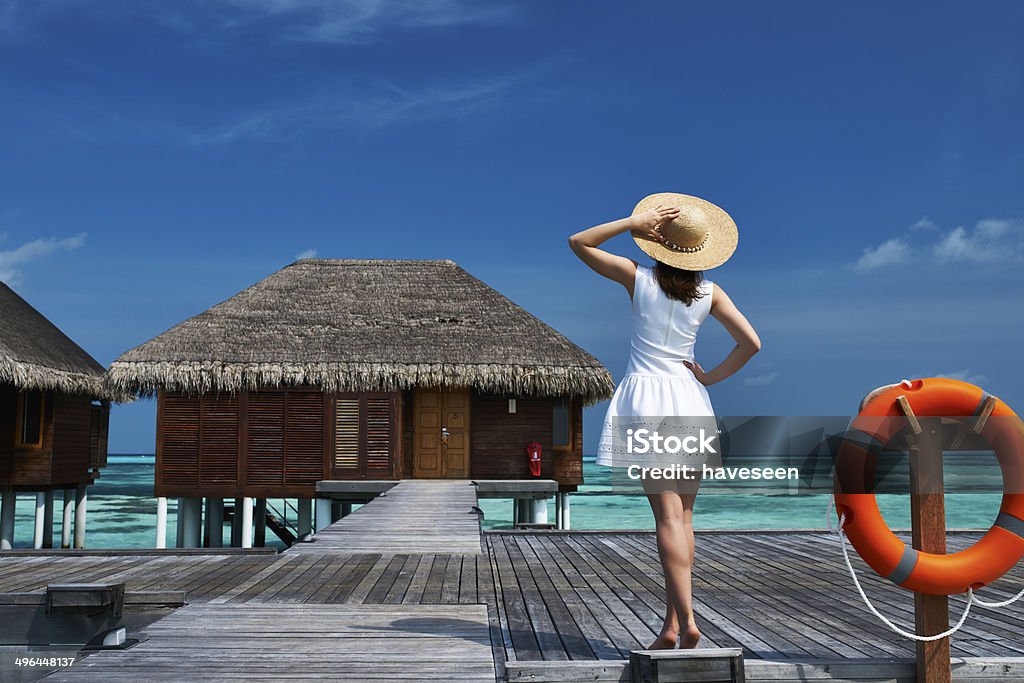 Woman on a beach jetty at Maldives Woman on a tropical beach jetty at Maldives Adult Stock Photo