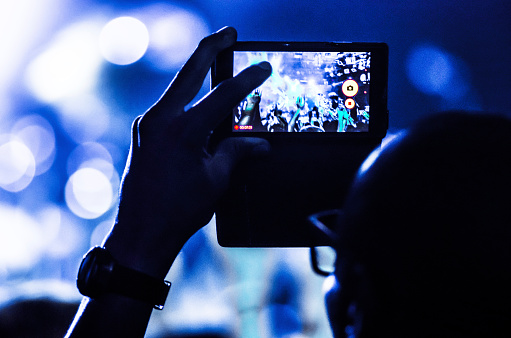 unrecognizable person with mobile in a concert
