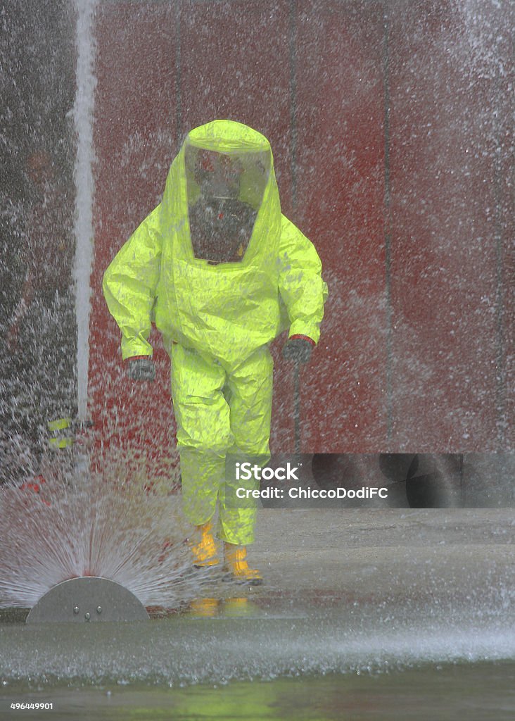 fireman with the yellow jumpsuit man with the yellow jumpsuit and the fire hydrant in action during a fire drill Occupational Safety And Health Stock Photo