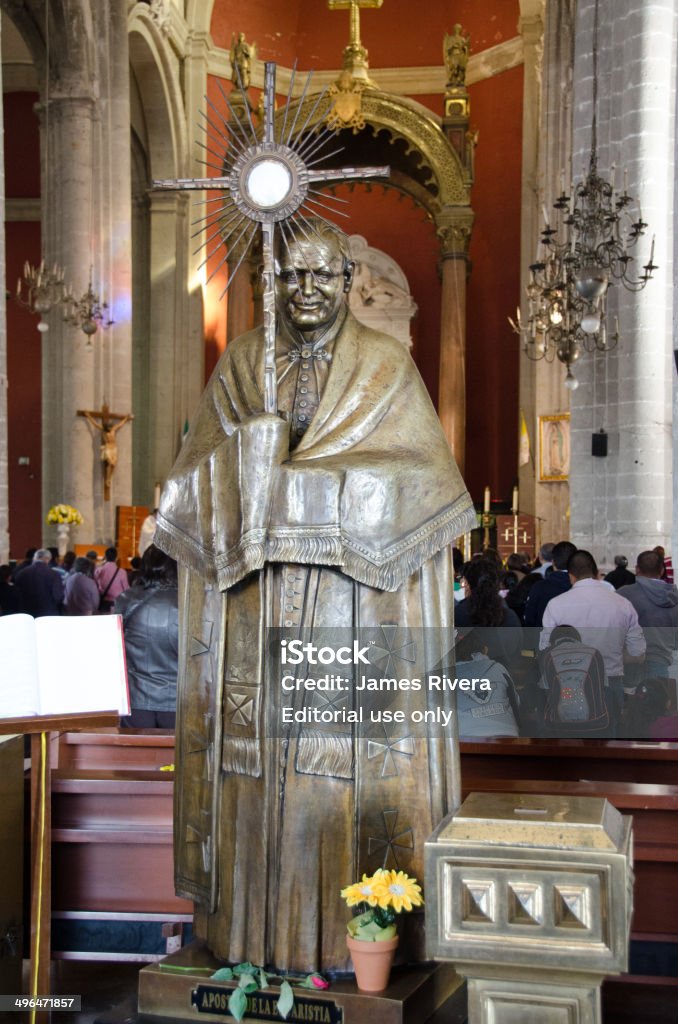 Old Basilica statue Mexico city, Mexico - February 2, 2014: The old basilica also known as the "Templo Expiatorio a Cristo Rey," the first structure of the old basilica begun in 1531. The photo focuses on a statue in the entrance of the old basilica. The people are tourist and residents. Basilica Stock Photo