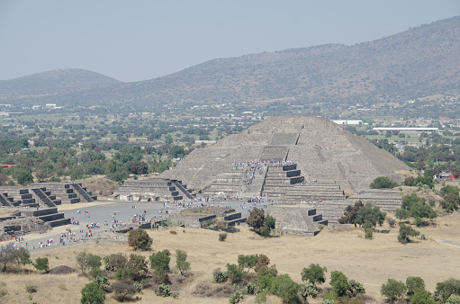 Valley of Mexico, Mexico - February 2, 2014: The photo was taken in the Teotihuacan pyramid site on top of the Sun Pyramid. The Moon Pyramid is in the main frame as well as the avenue of the dead and the people are tourist and residents.