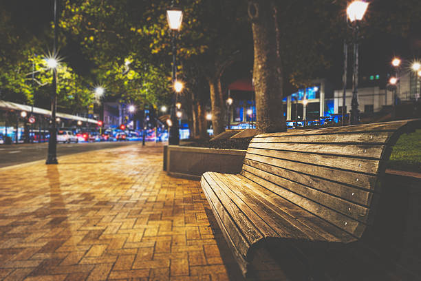 Bench on the street in Dunedin Bench on the night street in Dunedin, New Zealand. dunedin new zealand stock pictures, royalty-free photos & images