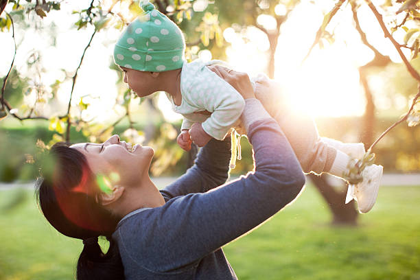 Family Mother and her daughter sitting in park apple-tree-flowers stock pictures, royalty-free photos & images