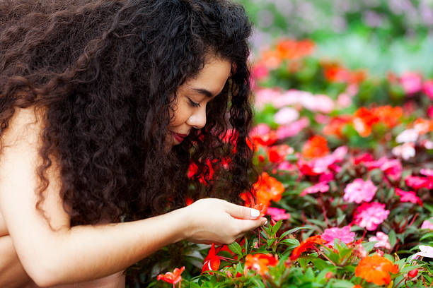 istock Young woman smelling flowers 496475595