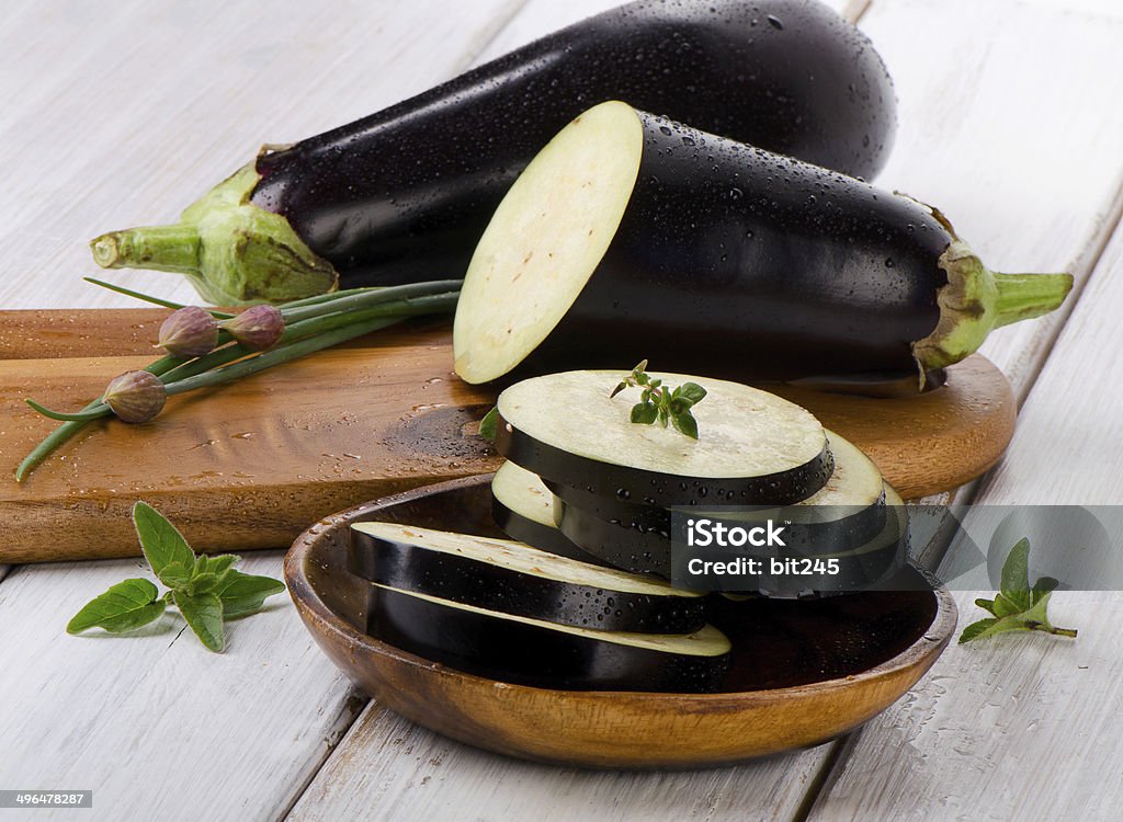 Eggplants Eggplants  on a wooden table with fresh herbs. Selective focus Dieting Stock Photo