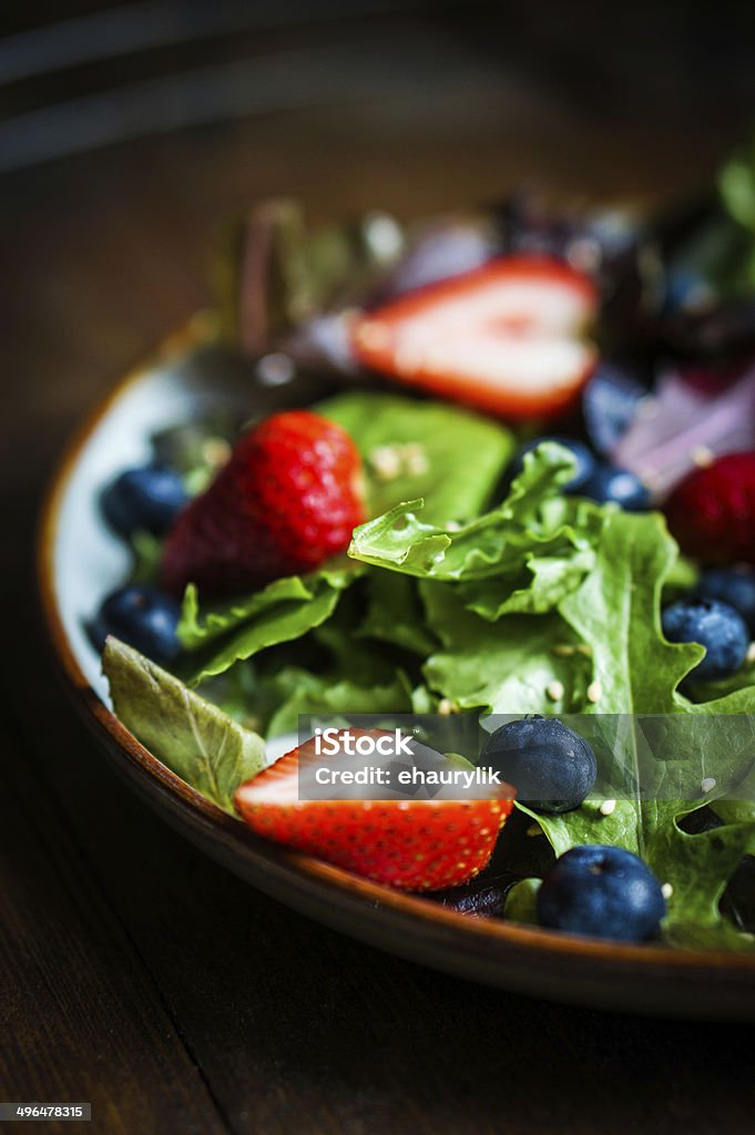Green salad with berries on wooden background Antioxidant Stock Photo